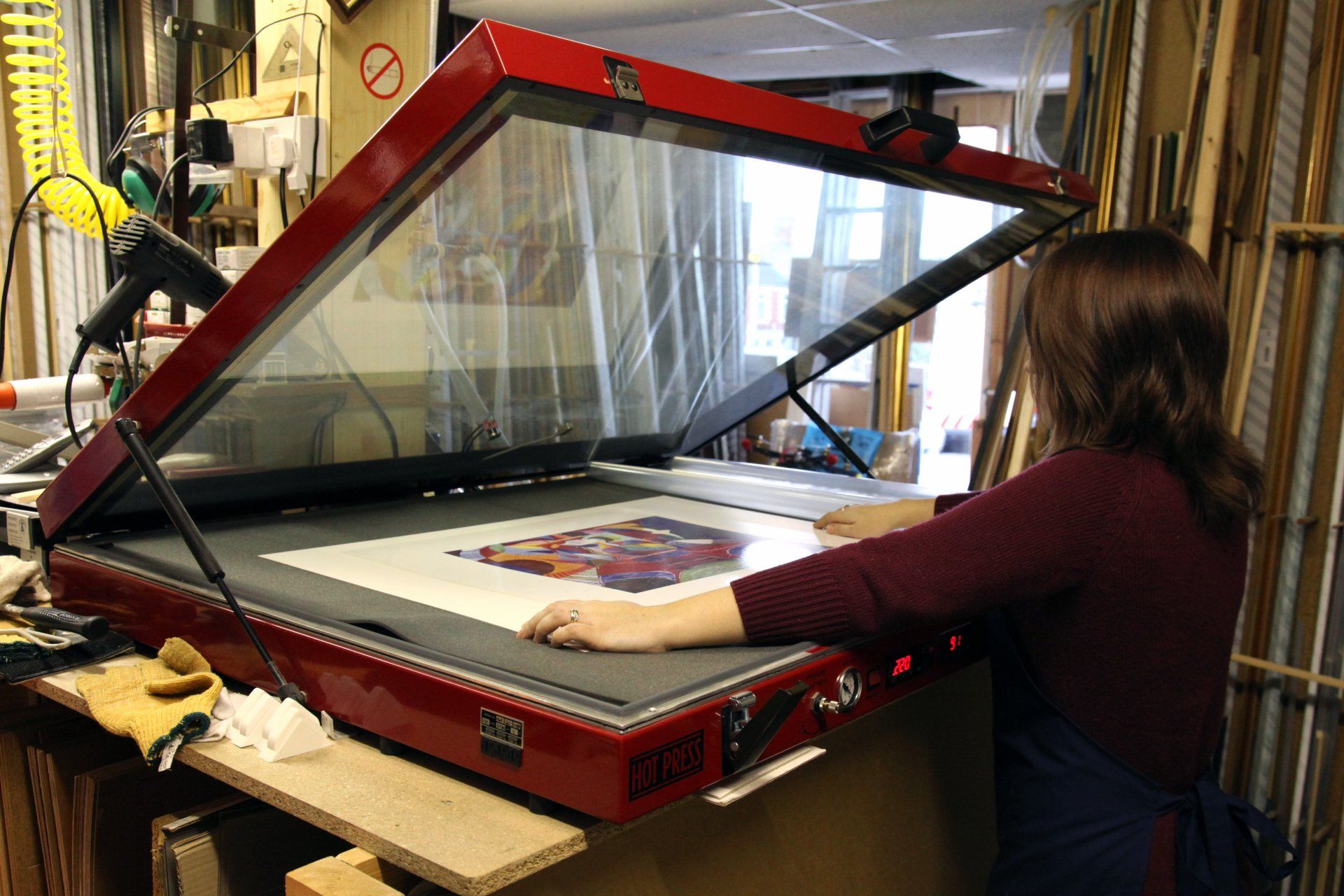 The heated dry-mounting press in use at the Penarth Framing workshop